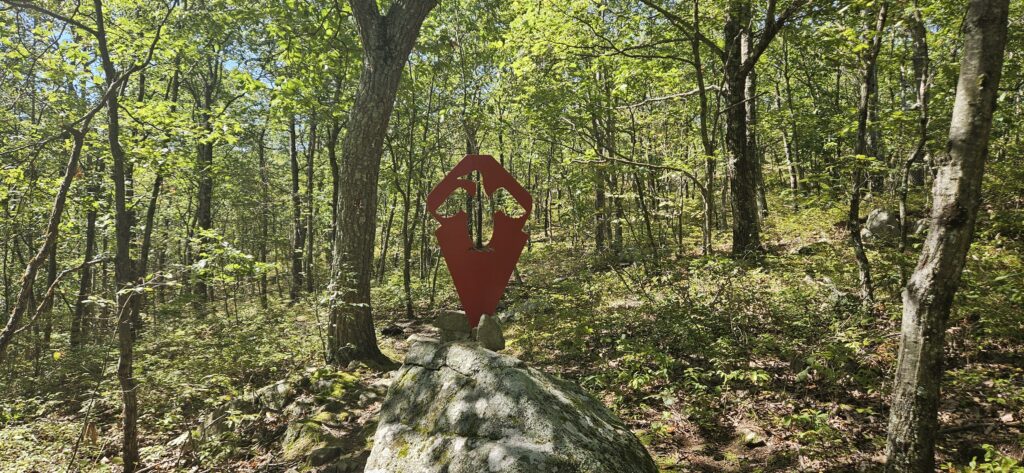 An image of a red sculpture using negative space to show a bird
