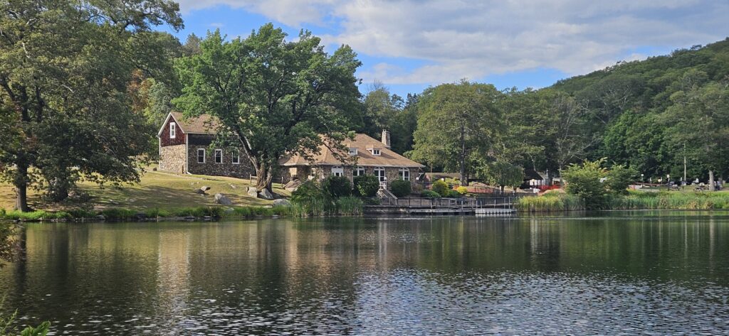 An image of an old building next to a scenic lake