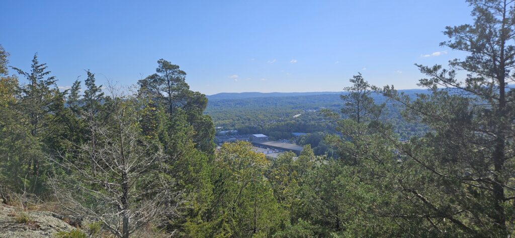 An image of an overlook featuring some warehouses in the front and mountains in the background