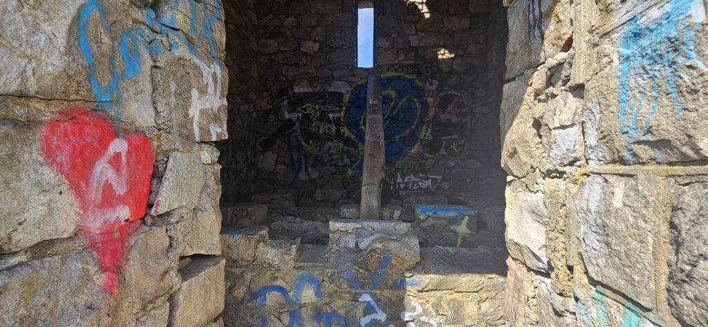 An image of the inside of an old and graffiti-covered stone building