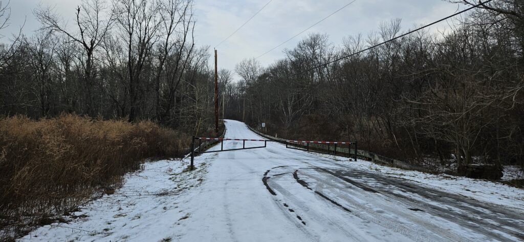 An image of a gate blocking Old Mine Road in the winter