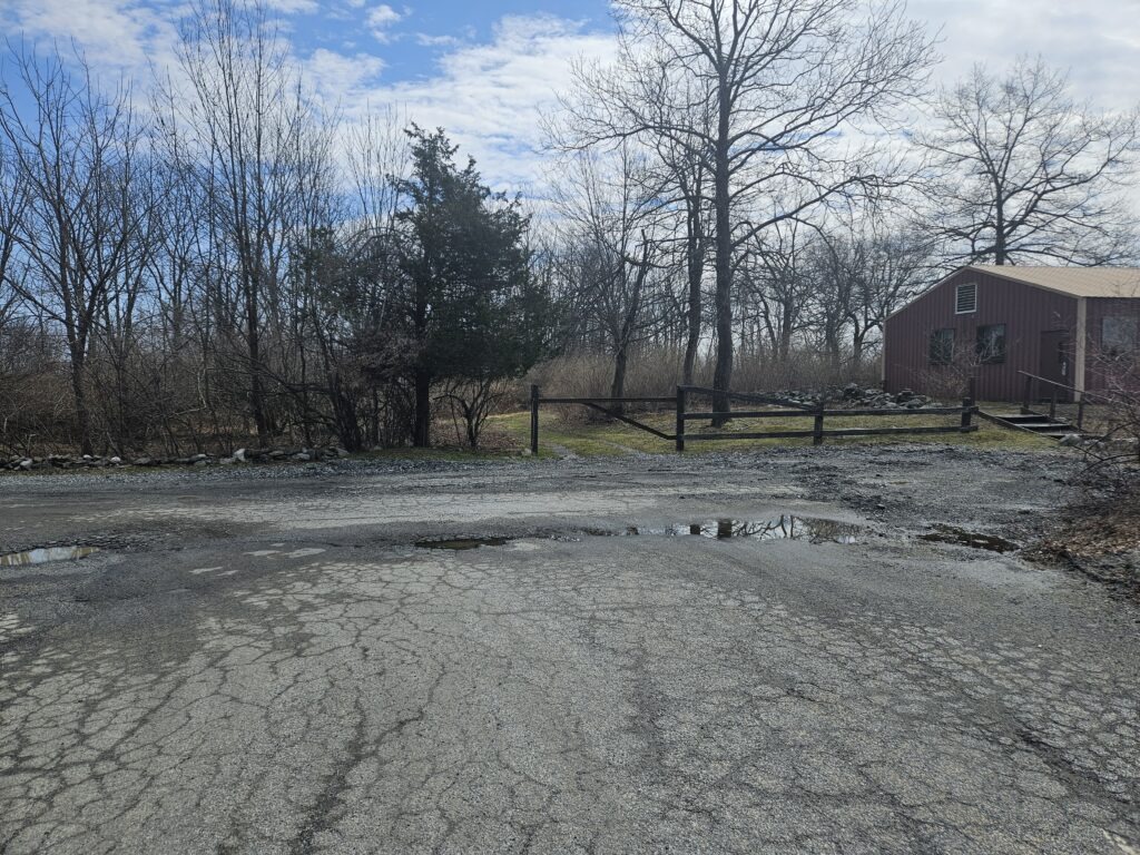 An image of an old building and gate in a parking lot