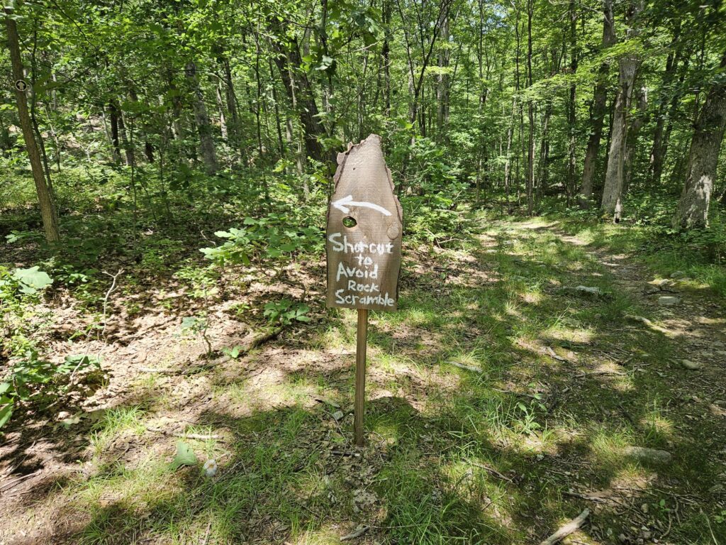 A sign directing hikers to a shortcut around a rock scramble at Apshawa Preserve