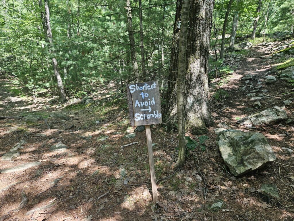 A sign pointing towards a shortcut around a rock scramble at Apshawa Preserve